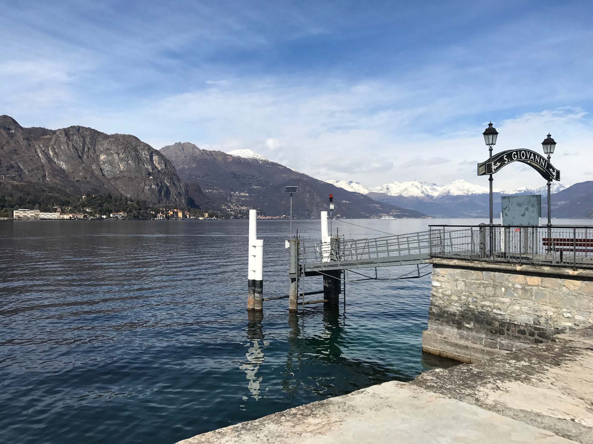 Il pontile di San Giovanni con le montagne innevate sullo sfondo